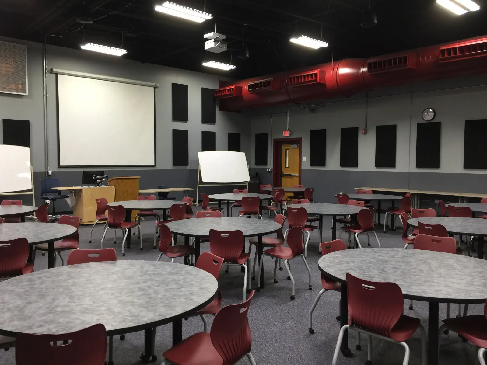 Many tables and chairs in front of a projector display in classroom W108B on the WIlsonville campus